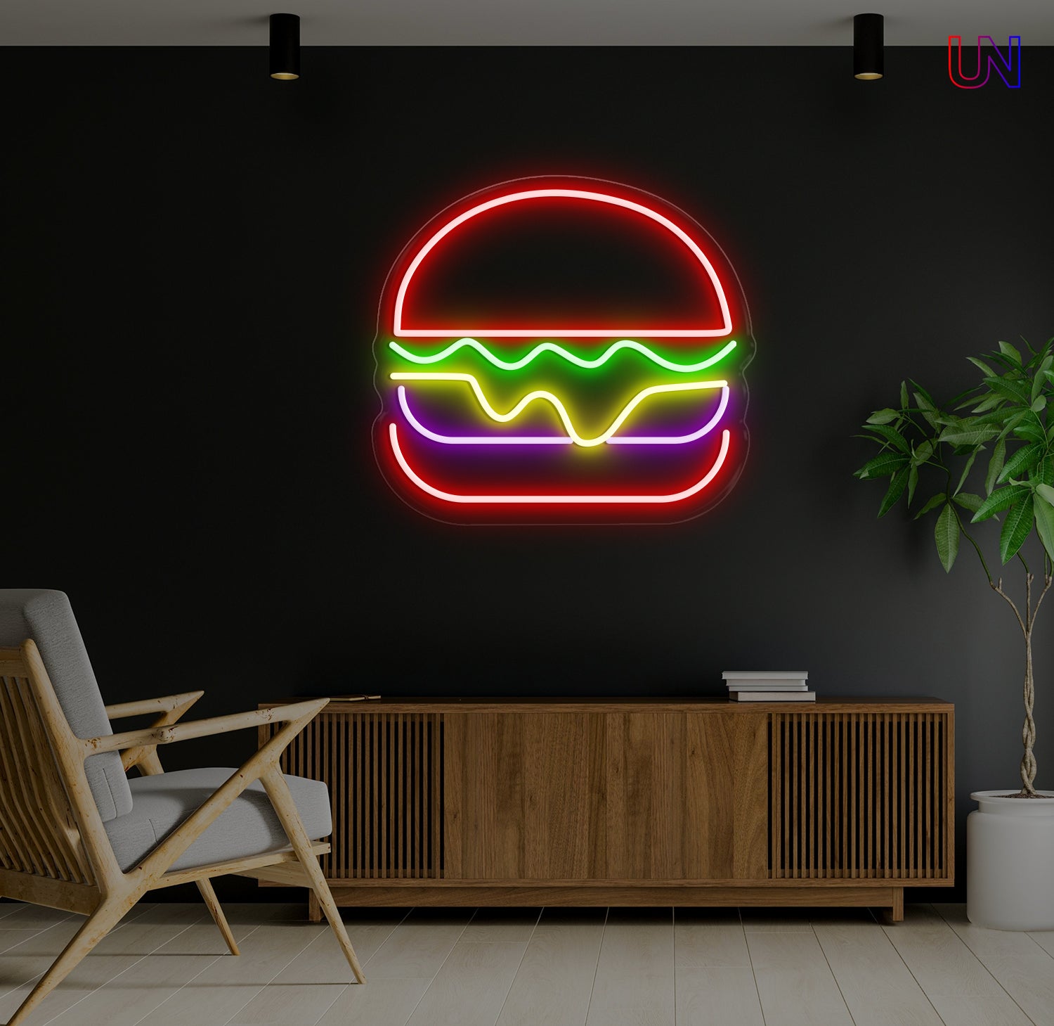 Neon sign of a burger on a dark wall with a chair and plant in the foreground