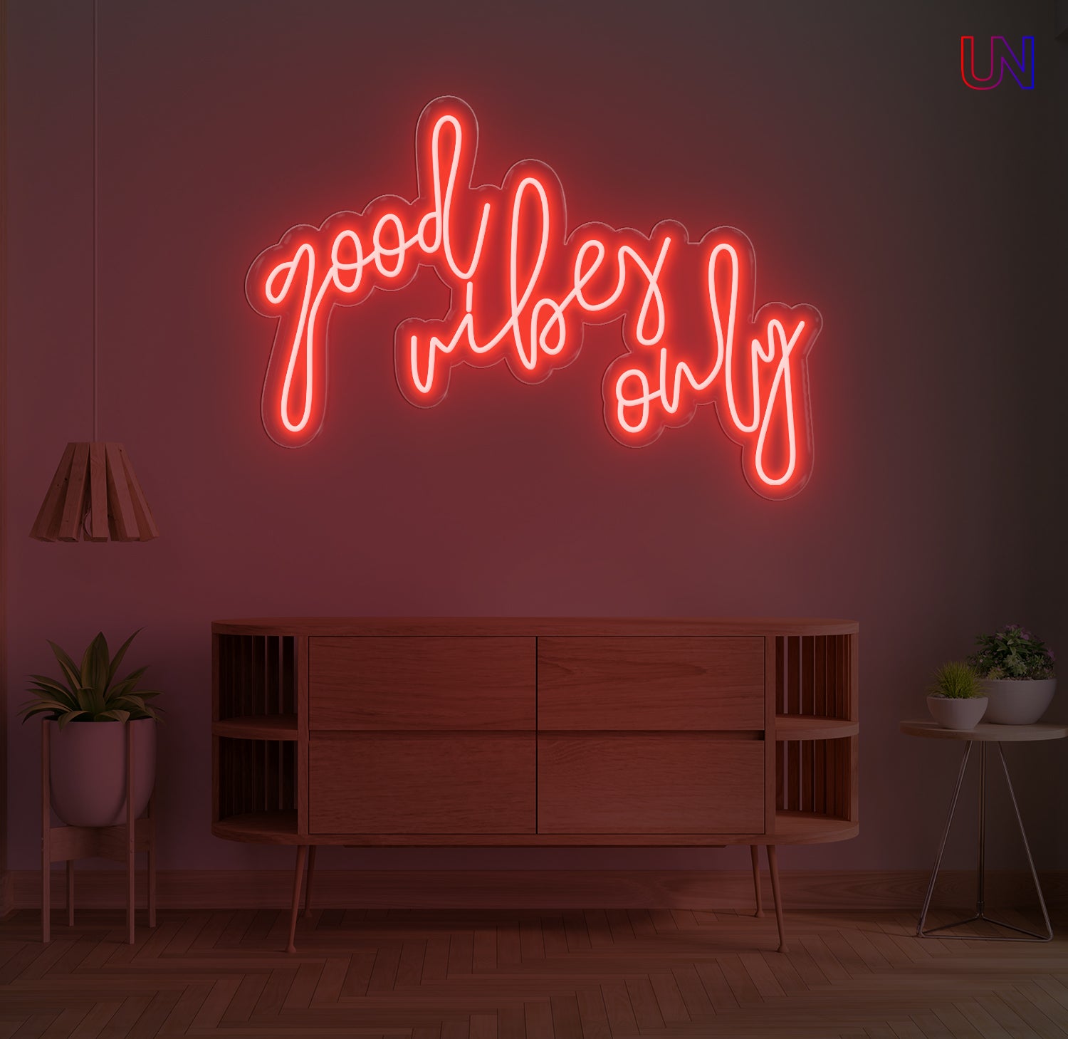 Neon sign with 'good Vibes only' on a wall in a room with wooden furniture and plants.