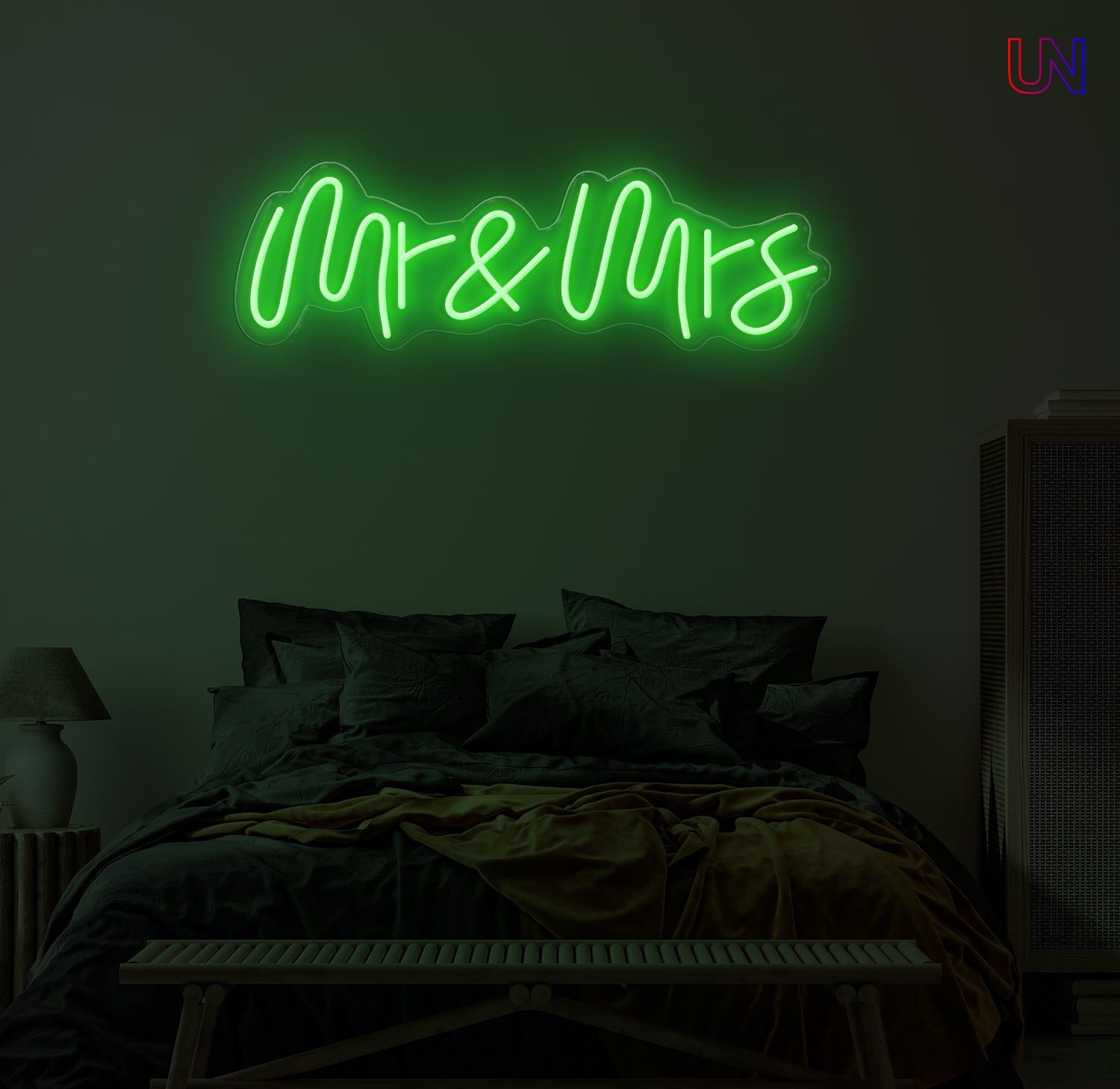 Neon sign reading 'Mr & Mrs' above a bed in a dimly lit room.