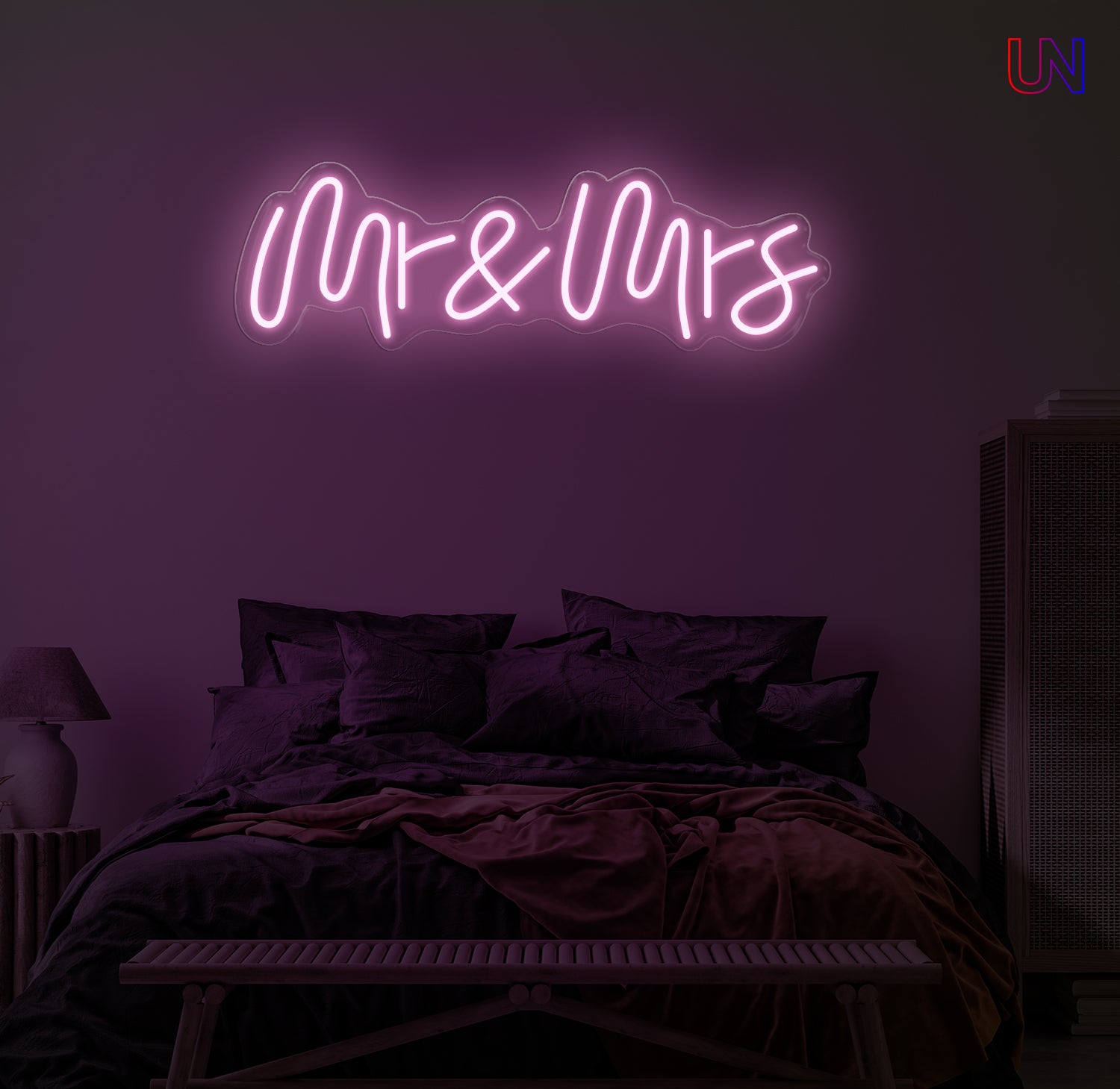 Neon sign reading 'Mr & Mrs' in a bedroom setting with dark purple tones.