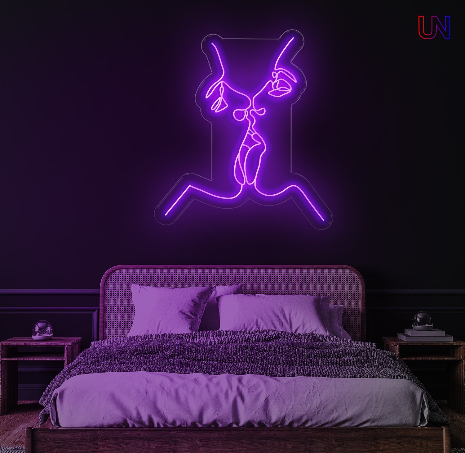 Neon light of a dancing figure on a dark wall above a bed in a bedroom.