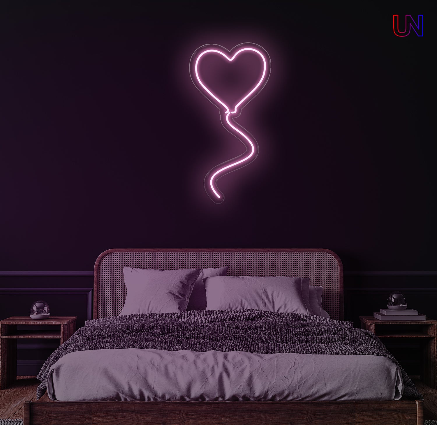 Neon heart-shaped light fixture above a bed in a dimly lit room