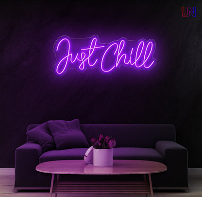 Neon sign with 'Just Chill' text in a modern living room setting.