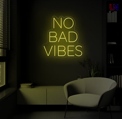 Neon sign saying 'No Bad Vibes' in a dark room with a chair.
